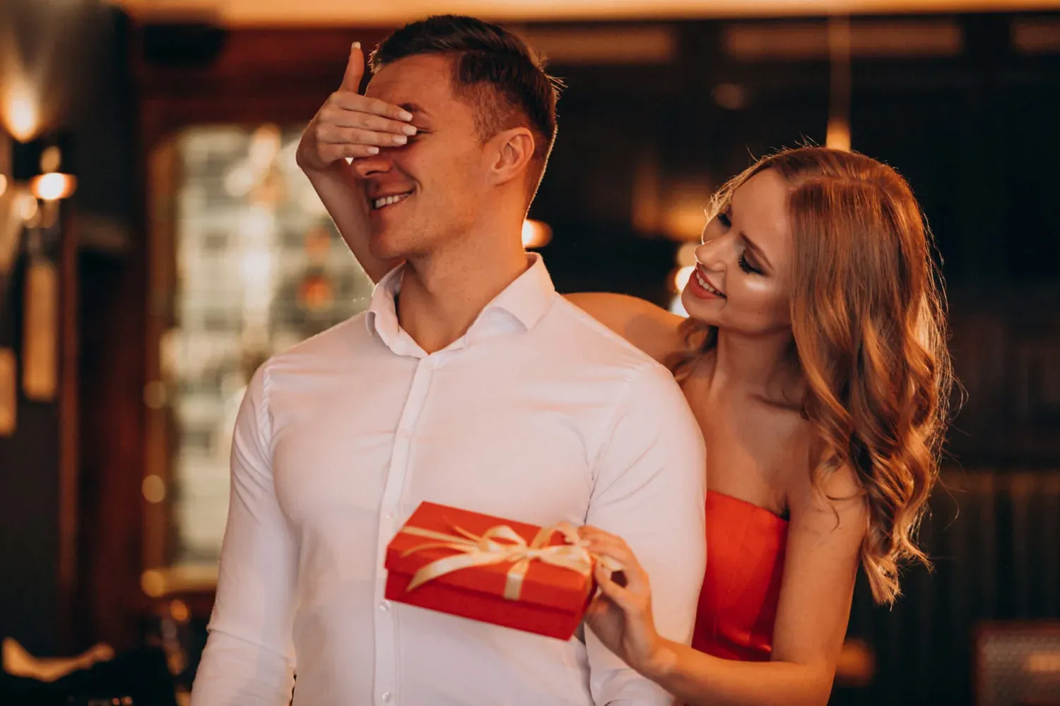Paar beim Flirten – sie überrascht ihn mit einem Geschenk