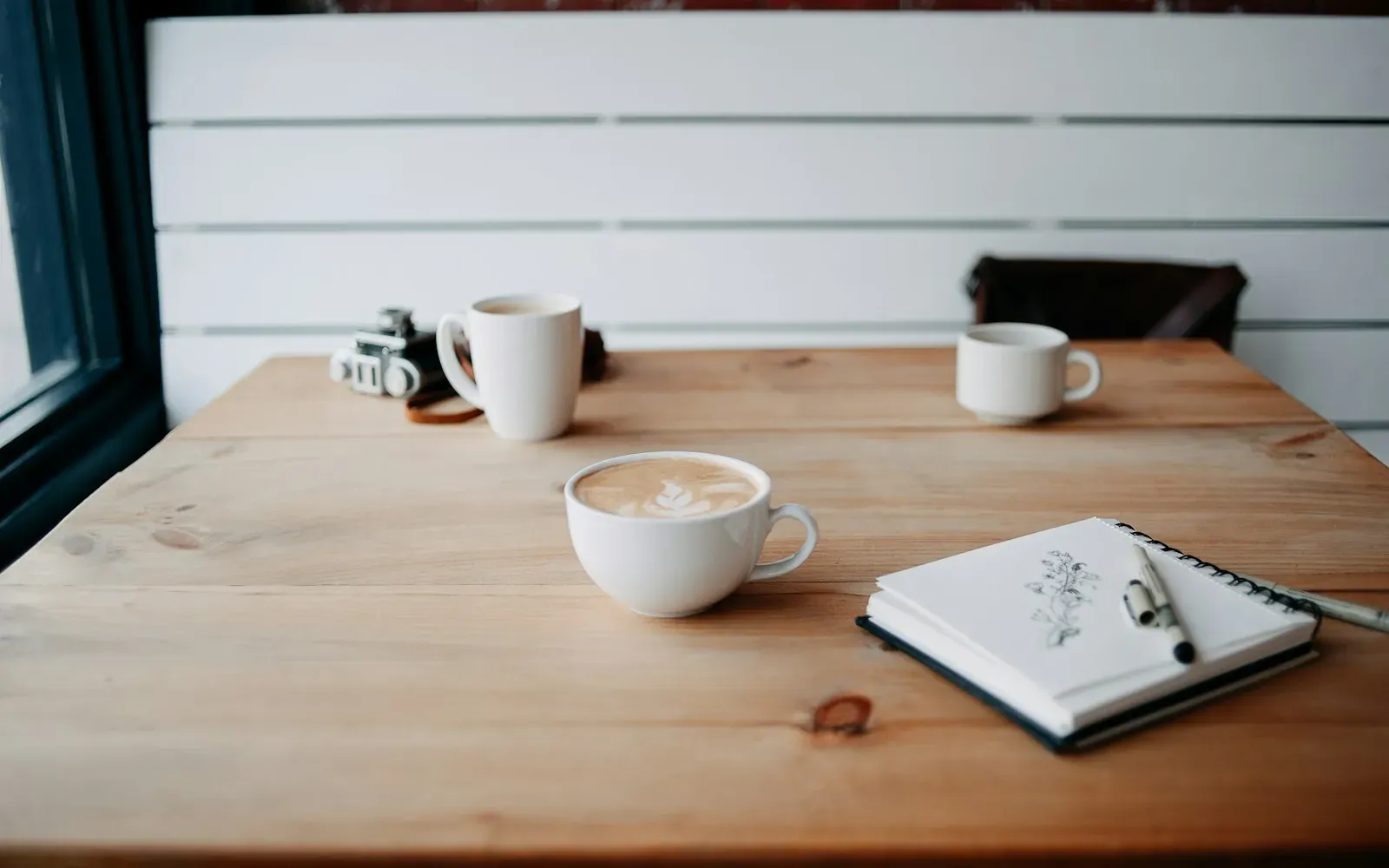 Kaffeetassen auf einem Holztisch in einem hellen Café